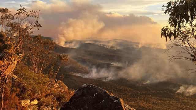 Bushfire destroys homes as calmer conditions on horizon