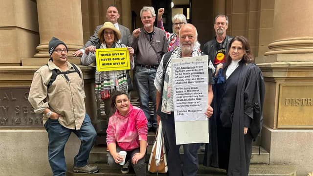 Massacre order poster on coloniser statue in court test