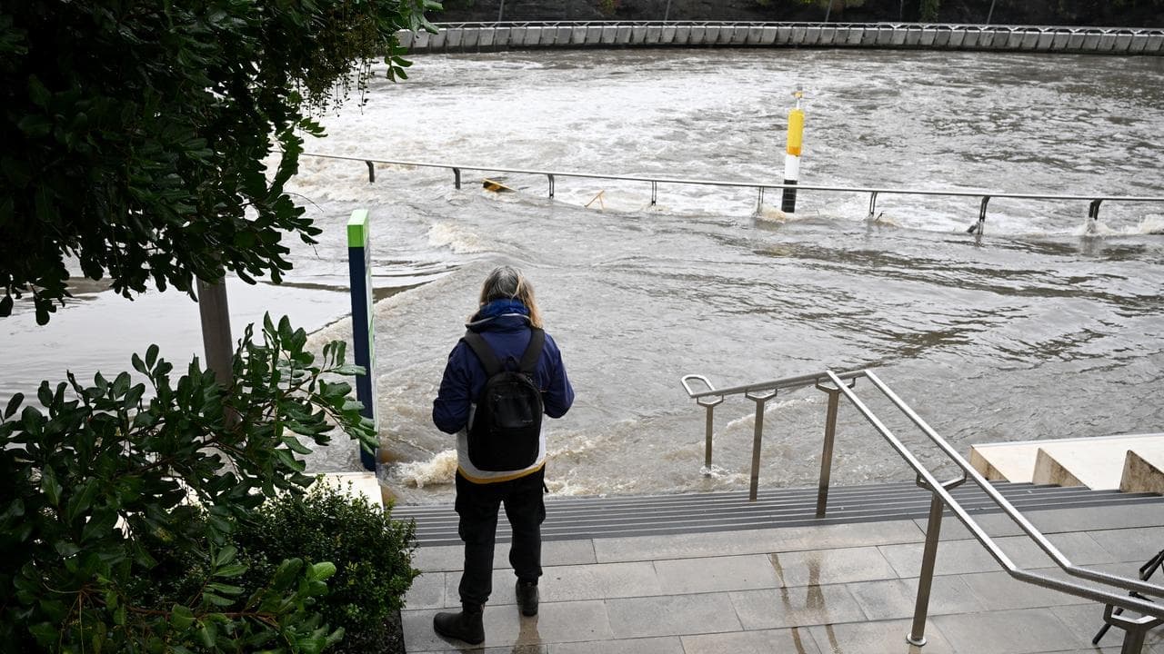 Father and son dead in river as flood threat grows