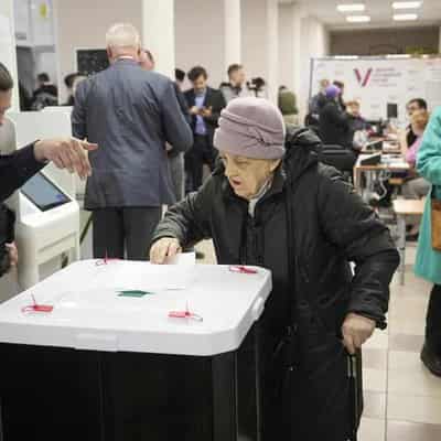 Russians vote as Ukraine attacks city, strikes refinery