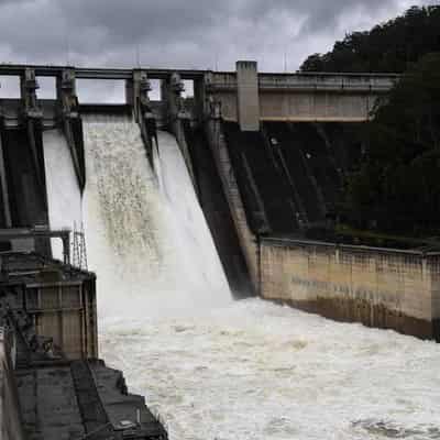 Largest dam spills, but axed wall extension defended