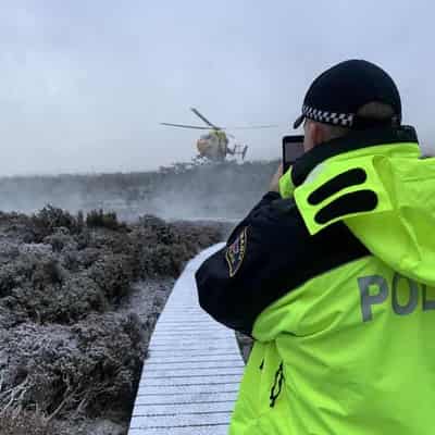 Child among bushwalkers waiting for rescue in snow