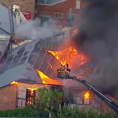 Brisbane blaze destroys building as man fights for life