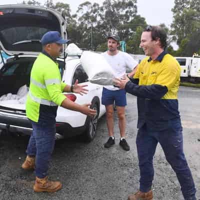 Sun bathing to sandbagging: nervous wait for cyclone